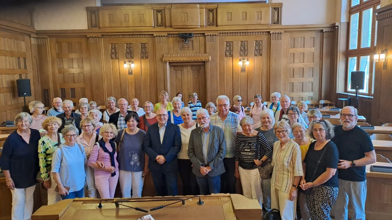 Reisegruppe der Volksbühne in einem holzgetäfelten Saal in Chemnitz